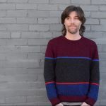 Ben Wheeler stands against brick wall