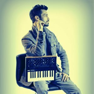 Andrew Stephen kneels on keyed instrument