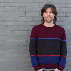 Ben Wheeler stands against brick wall